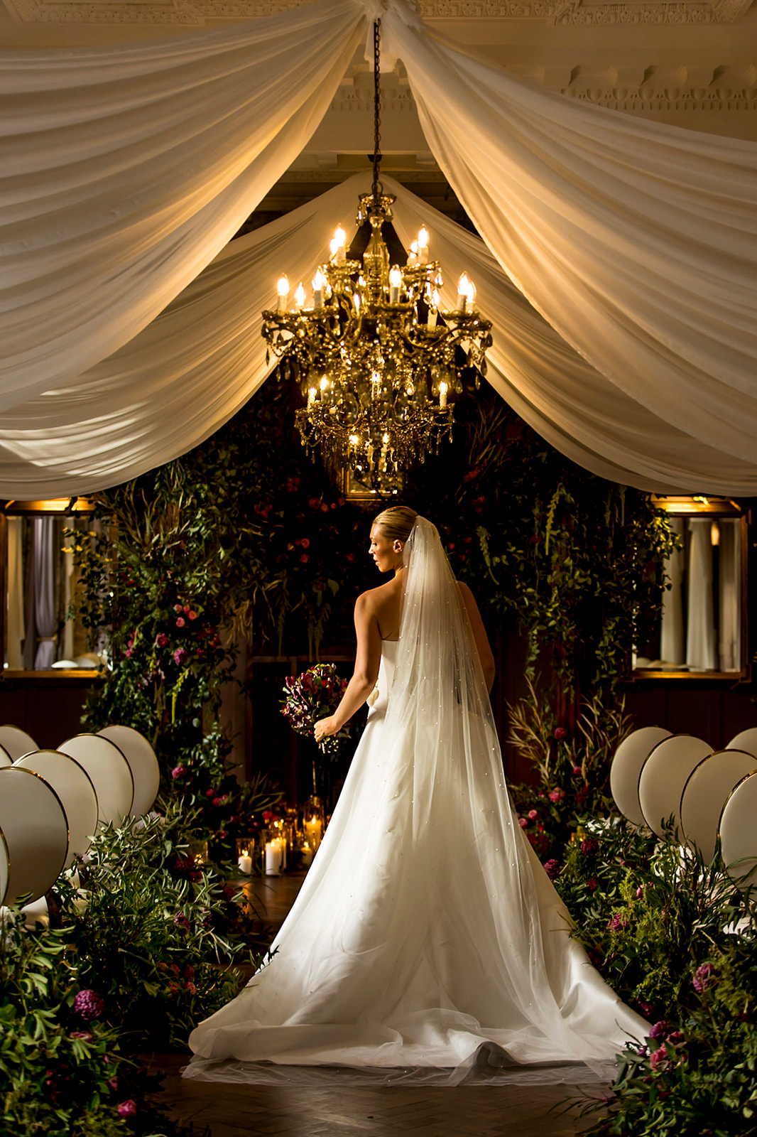 Draped ceremony setting with warm lighting at Ellingham Hall