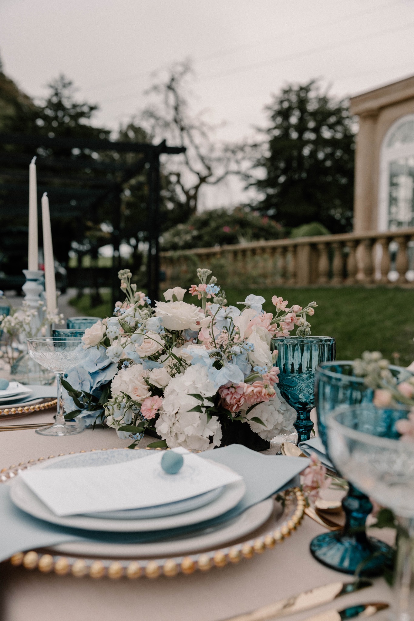 Outdoor wedding table with soft blue glassware and blush flowers