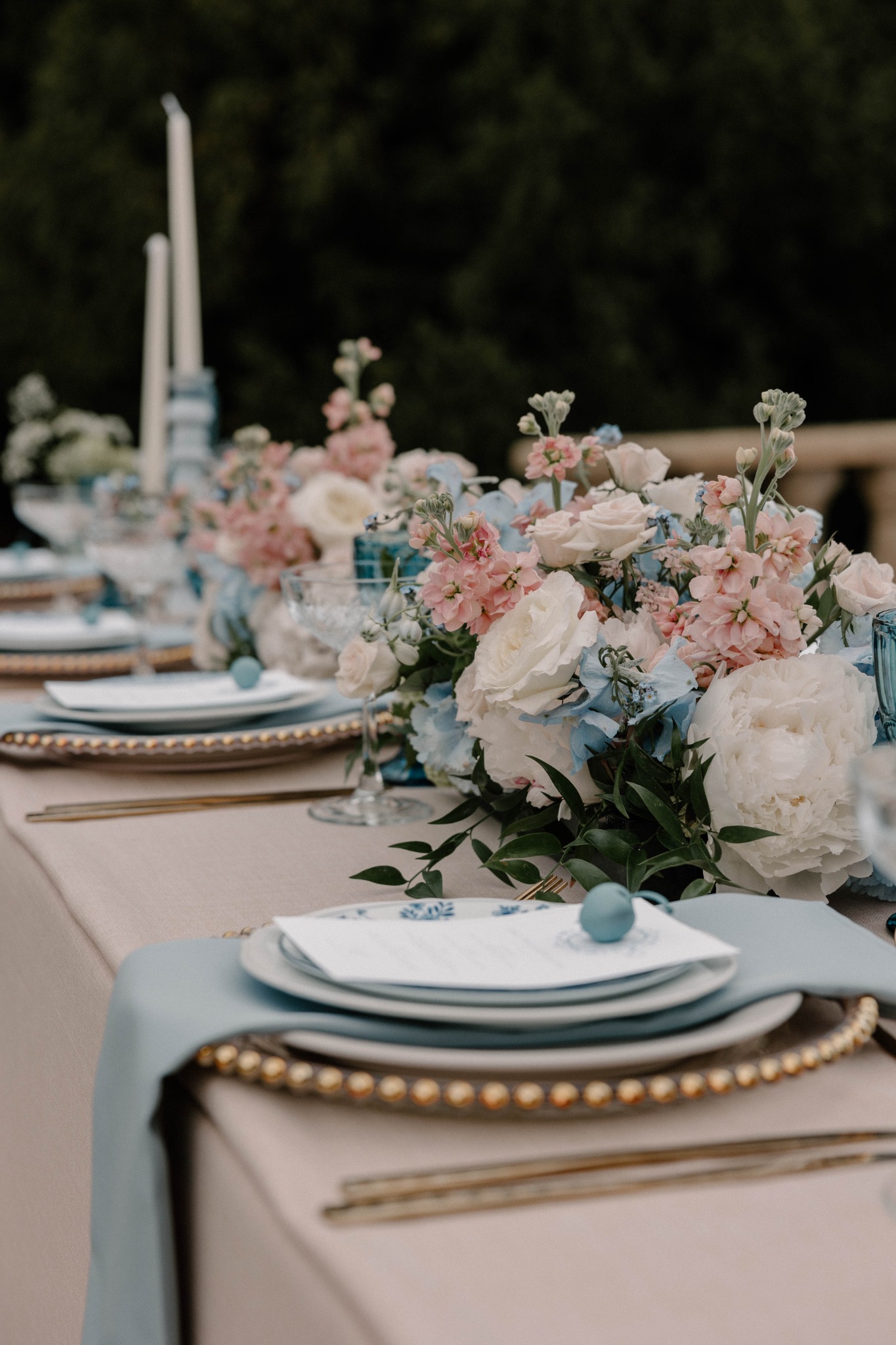 Pale blue and blush wedding table styling with layered place settings