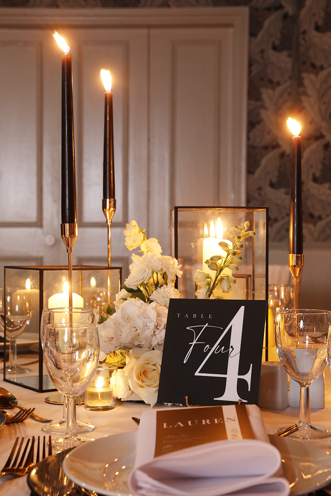 Candlelit wedding table with gold cutlery and thoughtful place details
