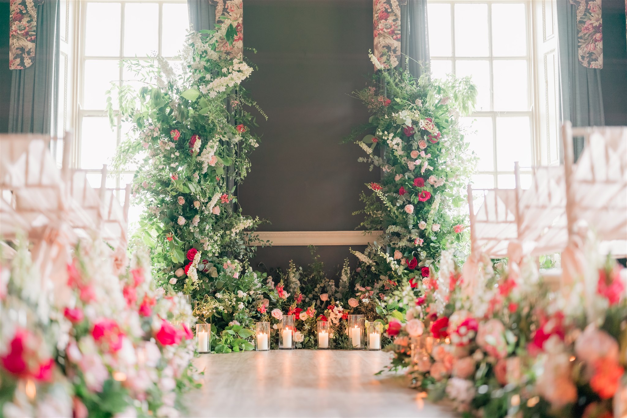 Wedding flowers around a candlelit fireplace at Lemmington Hall
