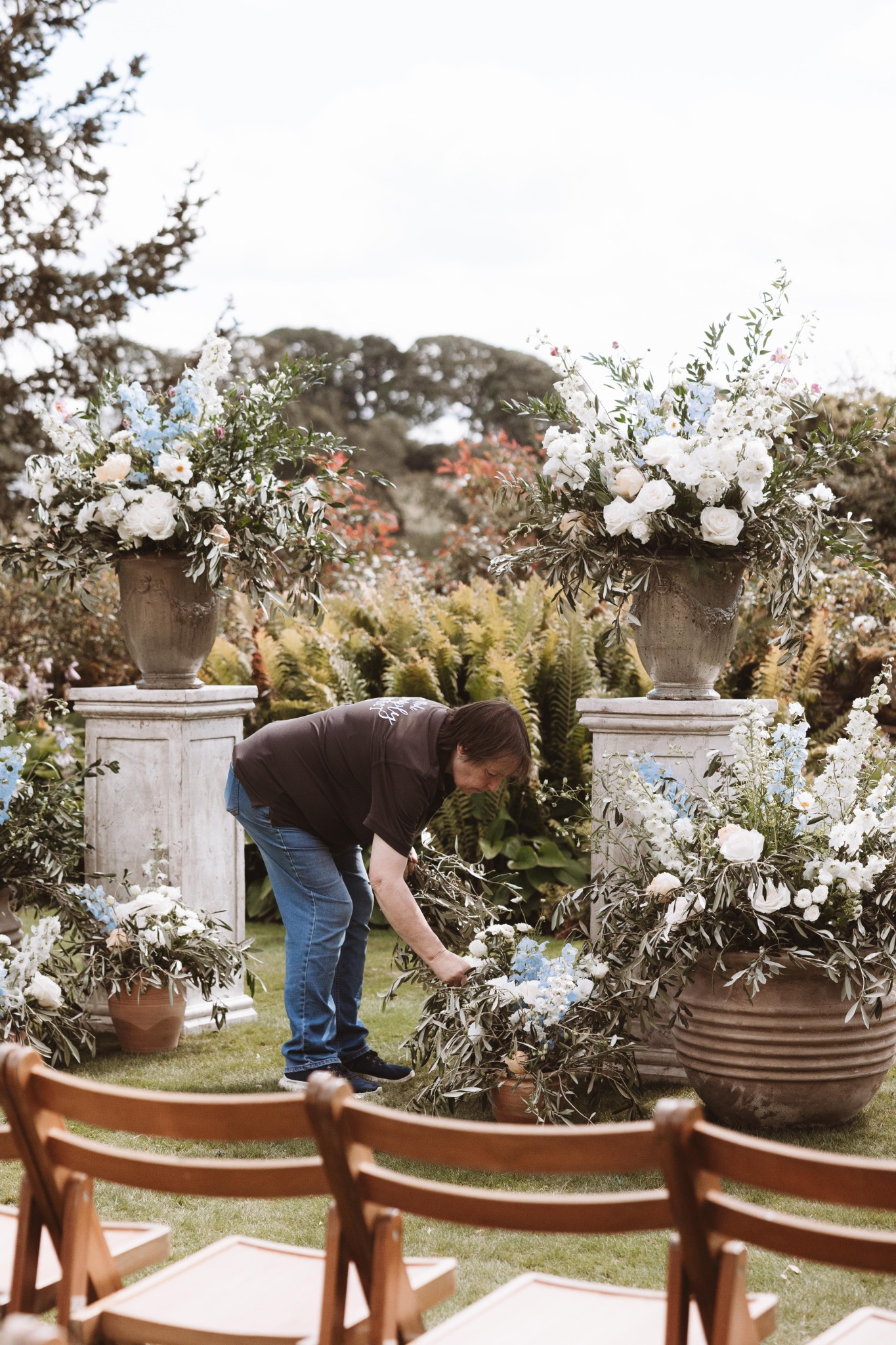 Susan arranging ceremony flowers between two urns