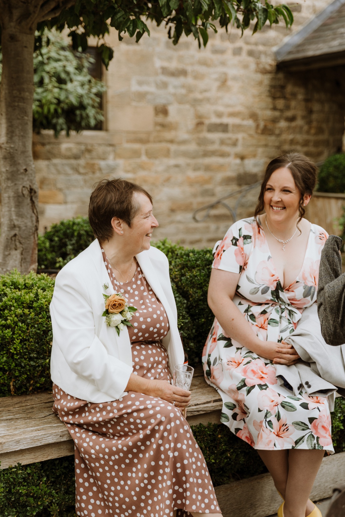Susan and Glynis smiling together at a wedding