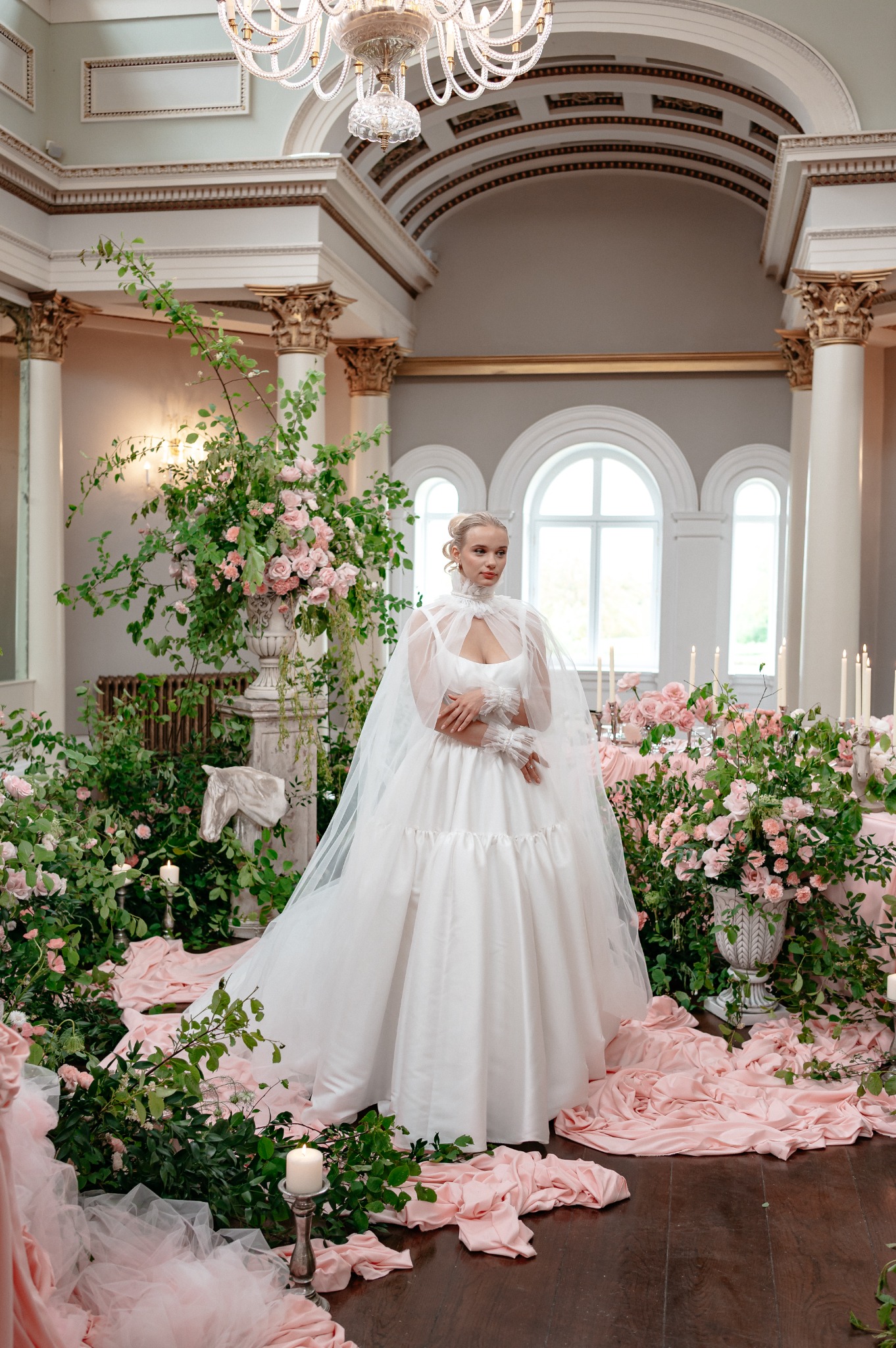 Bride surrounded by pink flowers, trailing foliage and draped fabric at Lartington Hall