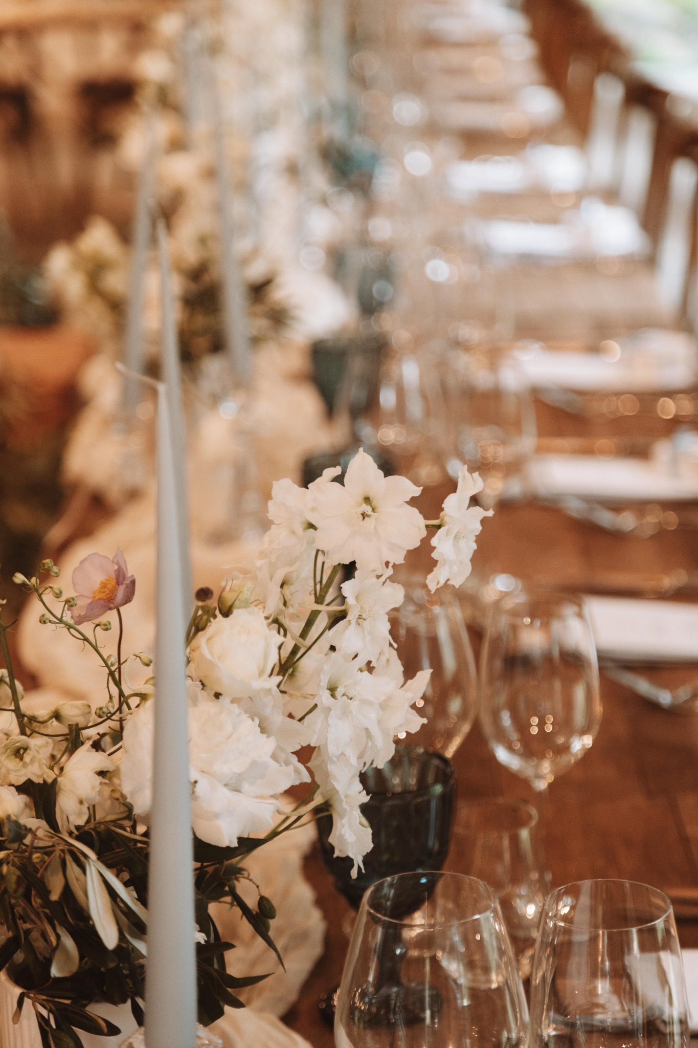 White flowers and taper candles along a reception table