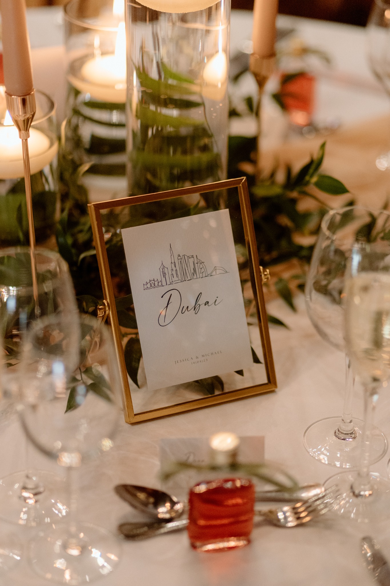 Table number framed among wedding flowers and place settings